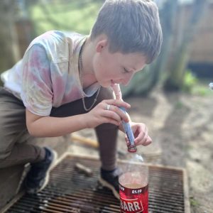 Young Person doing a science experiment with a packets of Mentos and a bottle of coke!