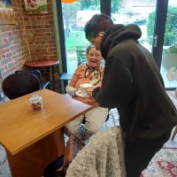 Young man serving coffee to a customer in our Cafe